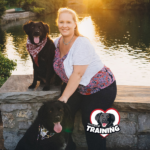 Author sitting outside near water with two dogs.