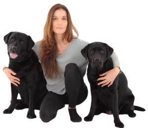 The author,  Anna Francesca Bradley, sitting on the floor with two large, black, sweet-looking dogs.