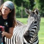 This article's author Michelle Martiya and a zebra. Both looking off in the same direction.